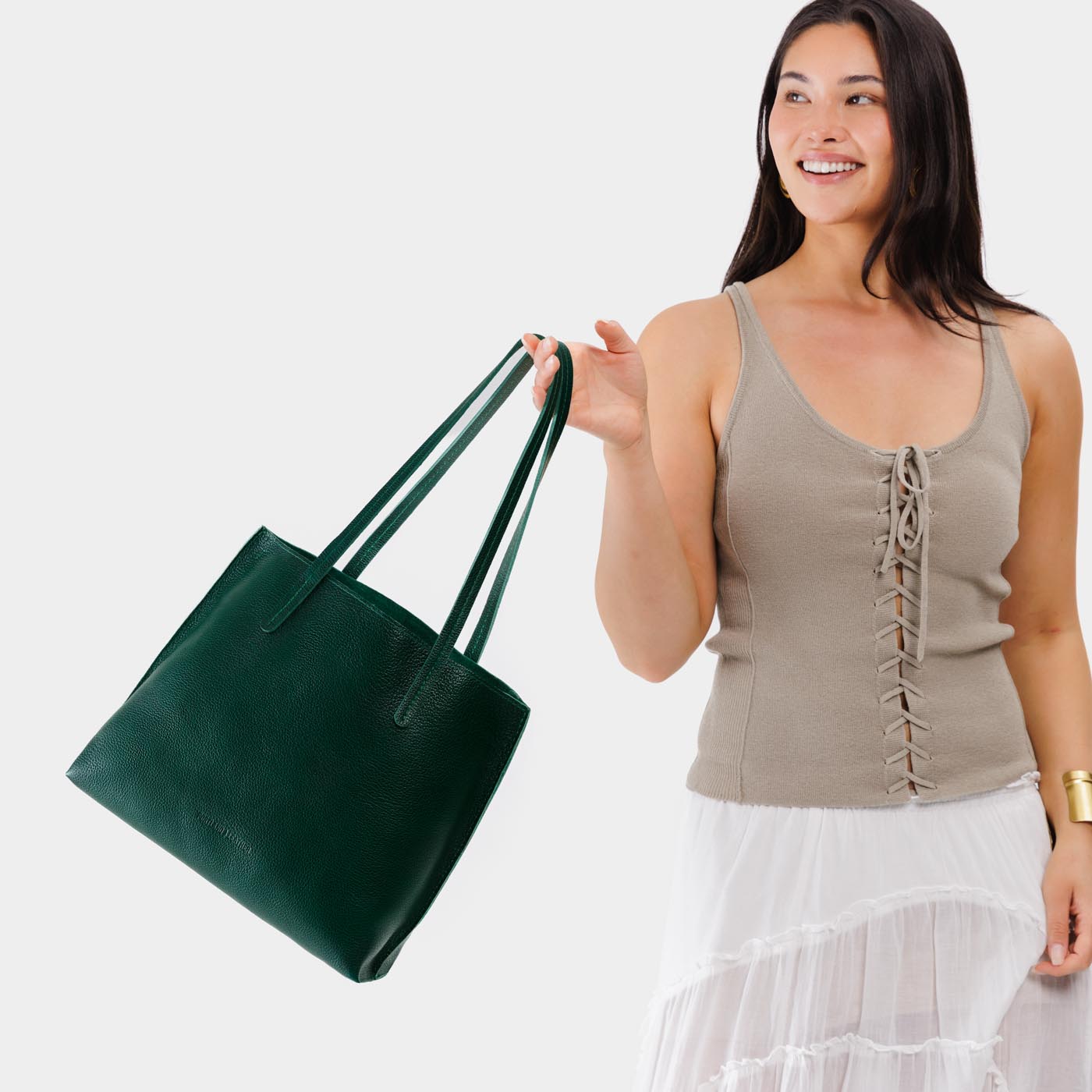 Forest Green*Medium | Model holding leather tote bag with interior snap key loop