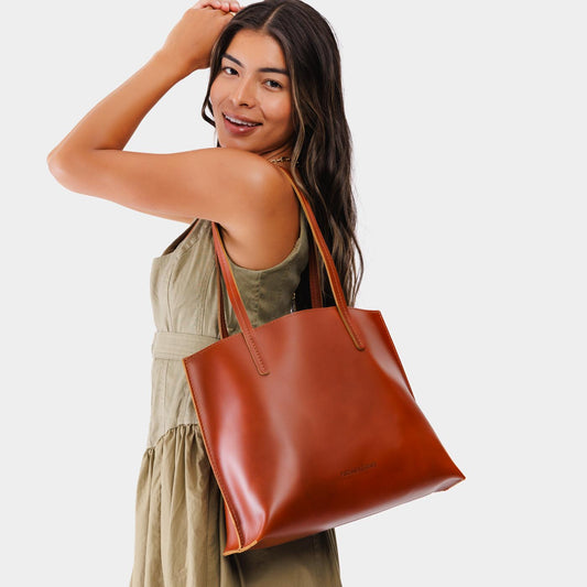Madrone*Medium | Model holding leather tote bag with interior snap key loop