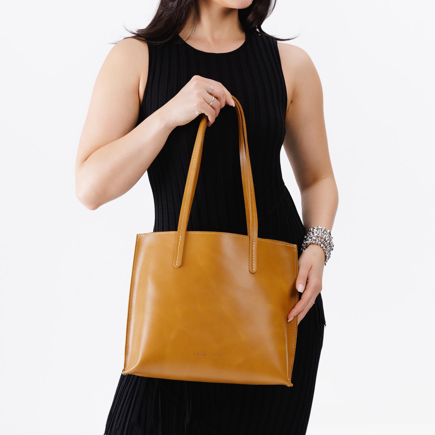 Mango*Medium | Model holding leather tote bag with interior snap key loop