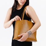 Mango Medium| Model holding leather tote bag with interior snap key loop