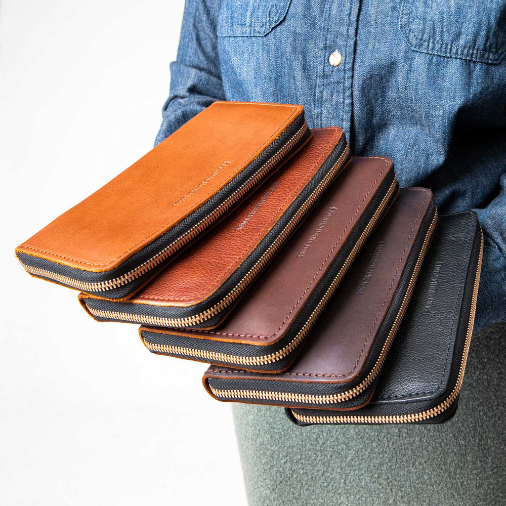 Woman holding leather wallets fanned out