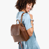 Asheville | Model wearing a leather backpack on a white background