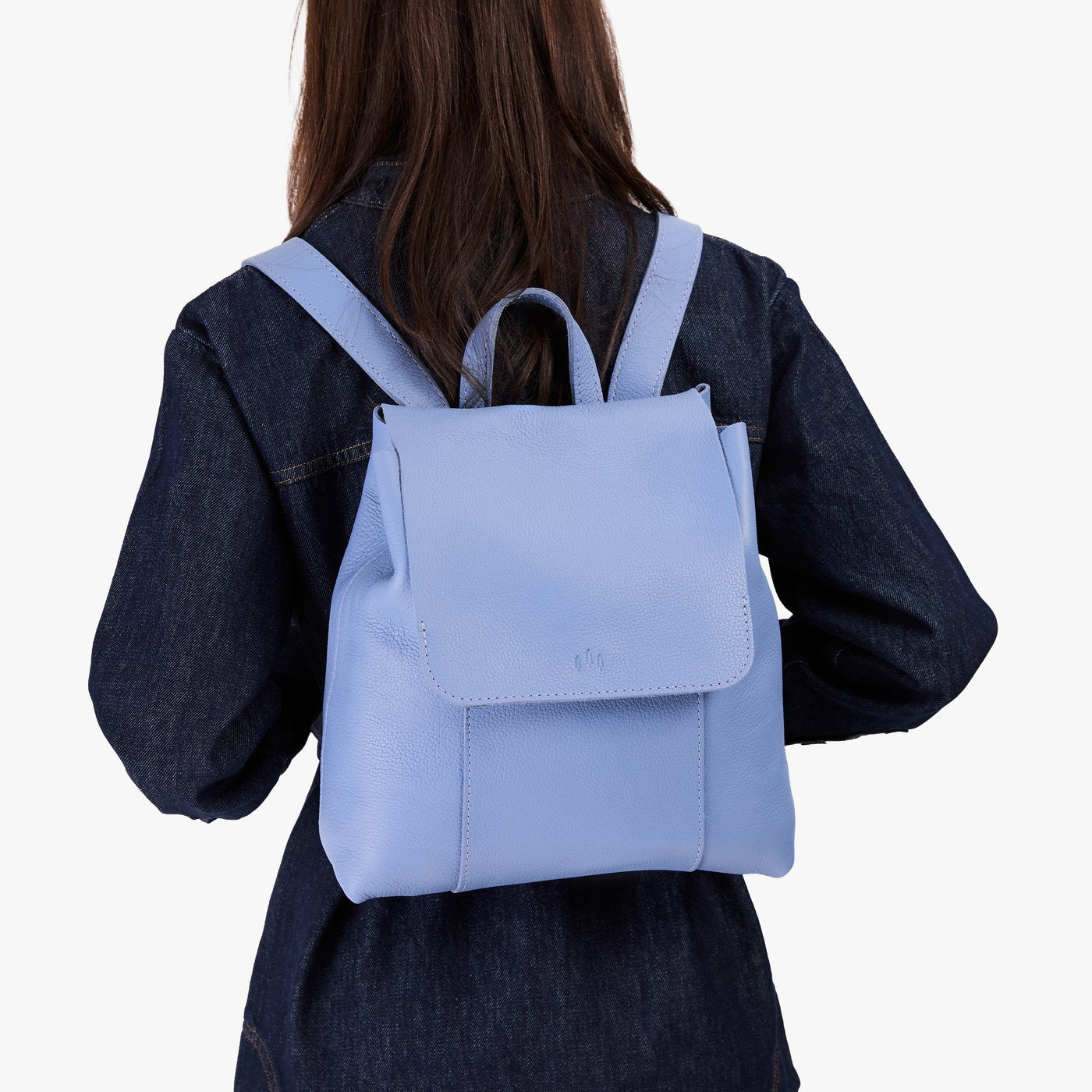 Aster | Model wearing a leather backpack on a white background