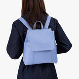 Aster | Model wearing a leather backpack on a white background