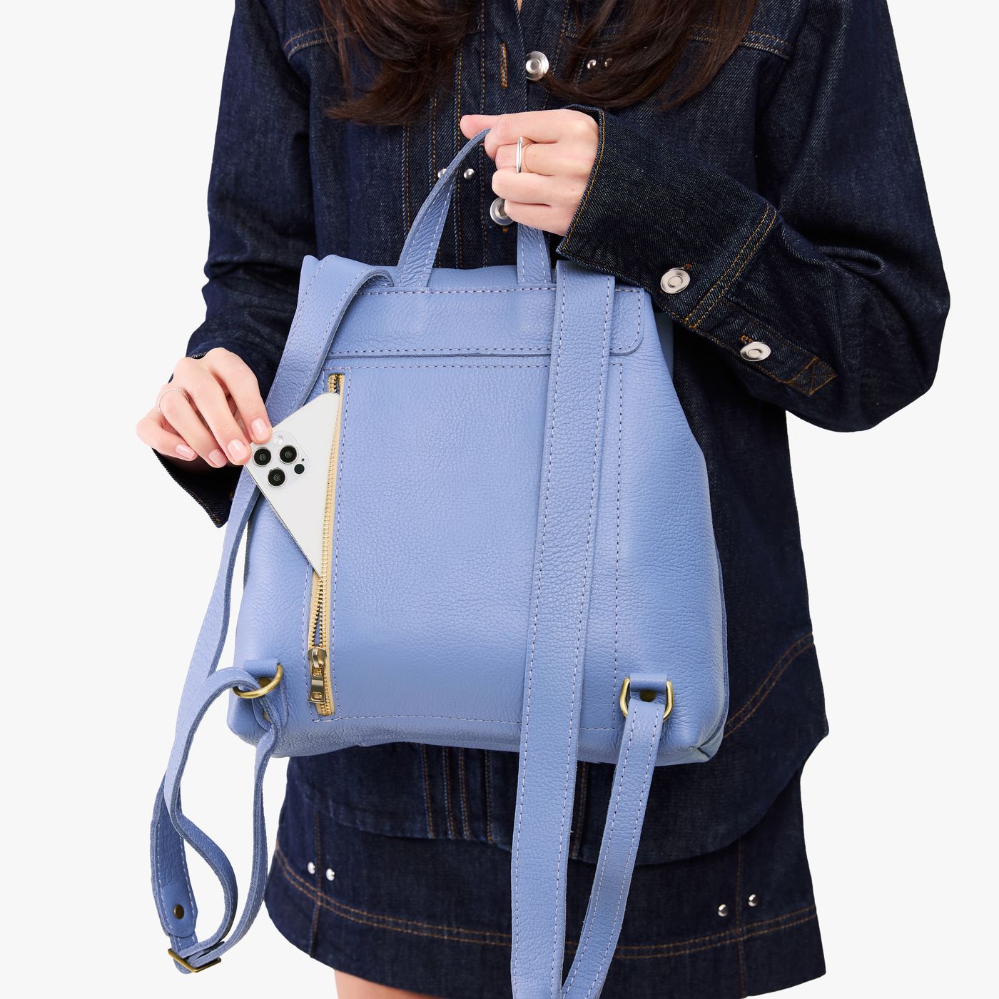 Aster | Model wearing a leather backpack on a white background