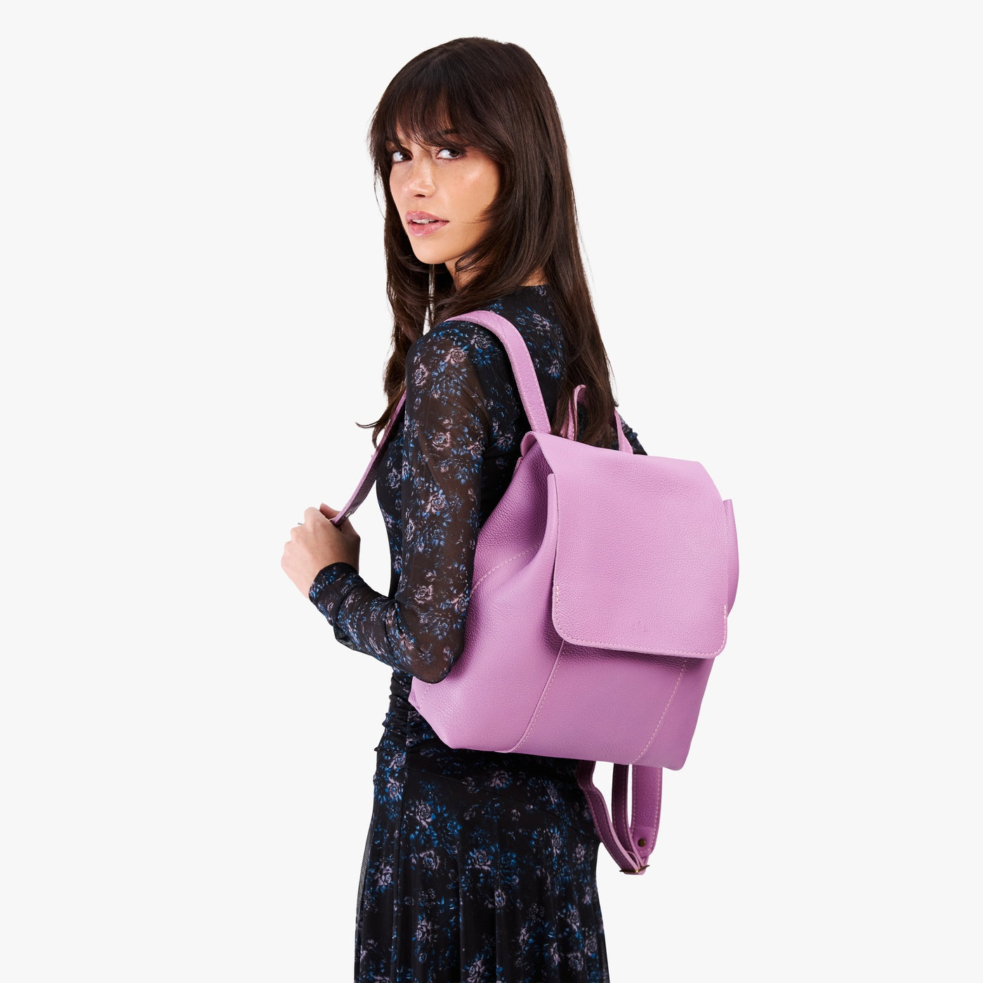 Calla Lily | Model wearing a leather backpack on a white background