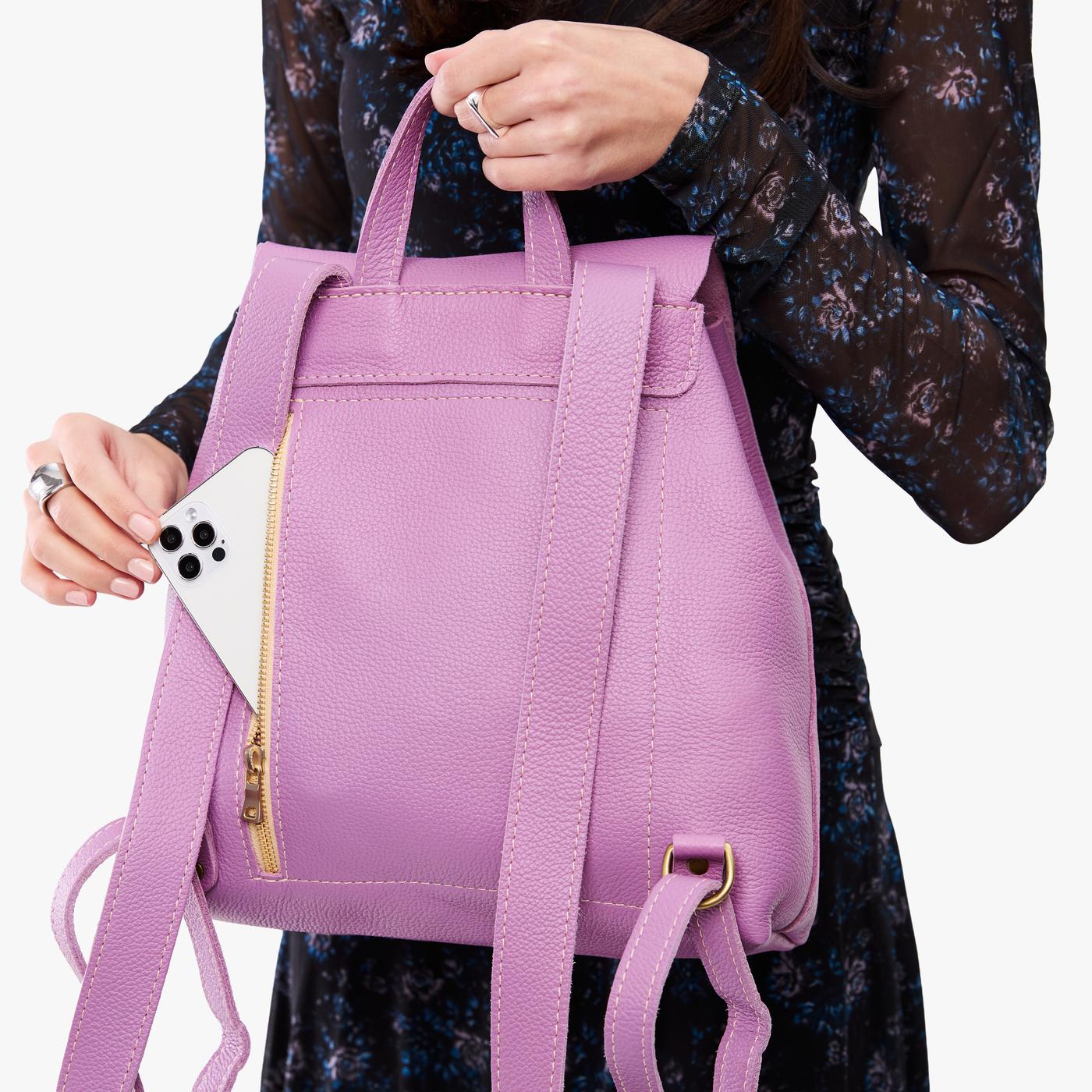 Calla Lily | Model wearing a leather backpack on a white background