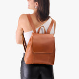 Honey | Model wearing a leather backpack on a white background