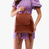 Nutmeg | Model wearing a leather backpack on a white background
