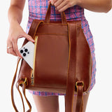 Nutmeg | Model wearing a leather backpack on a white background