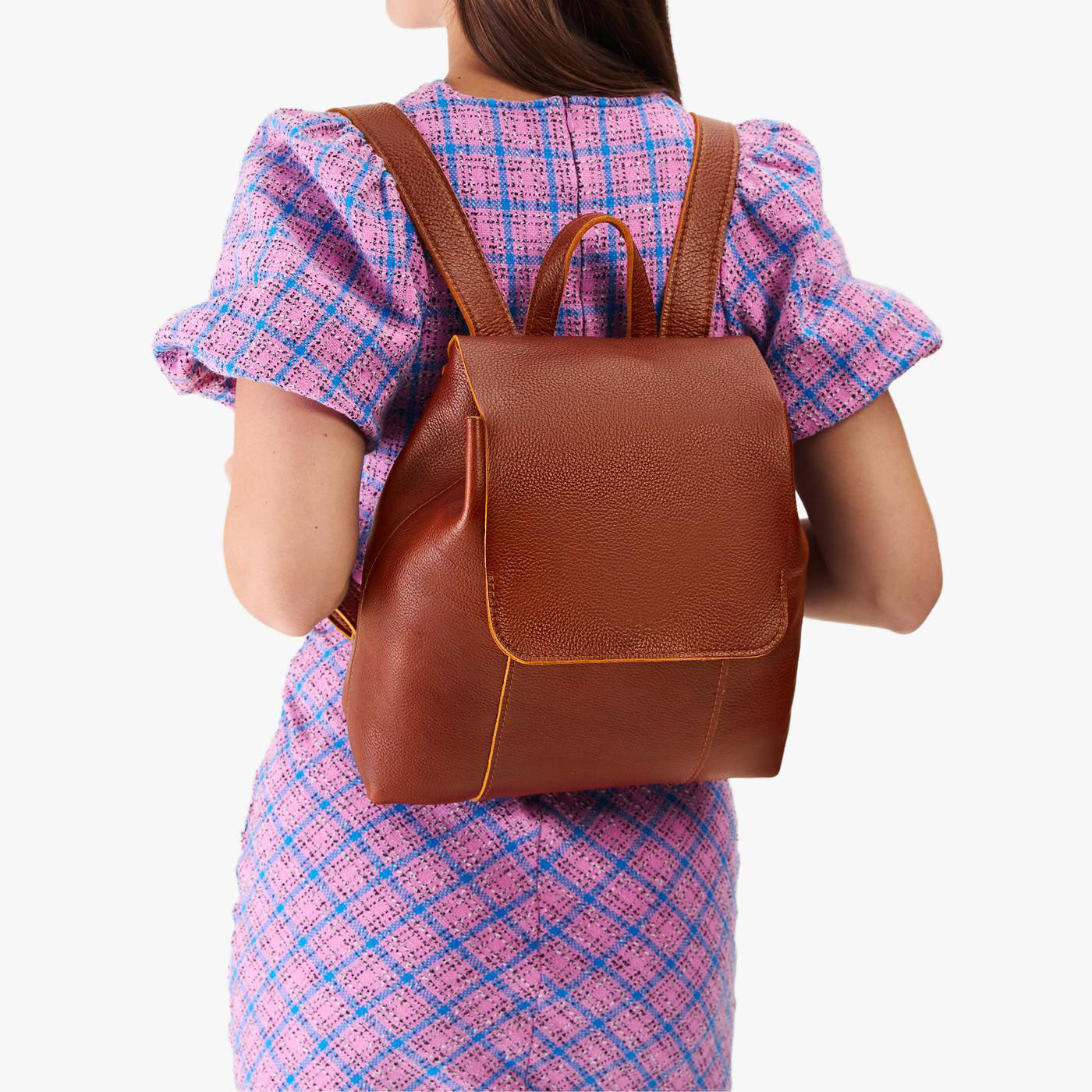 Nutmeg | Model wearing a leather backpack on a white background