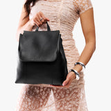 Pebbled--black | Model wearing a leather backpack on a white background