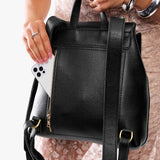 Pebbled--black | Model wearing a leather backpack on a white background