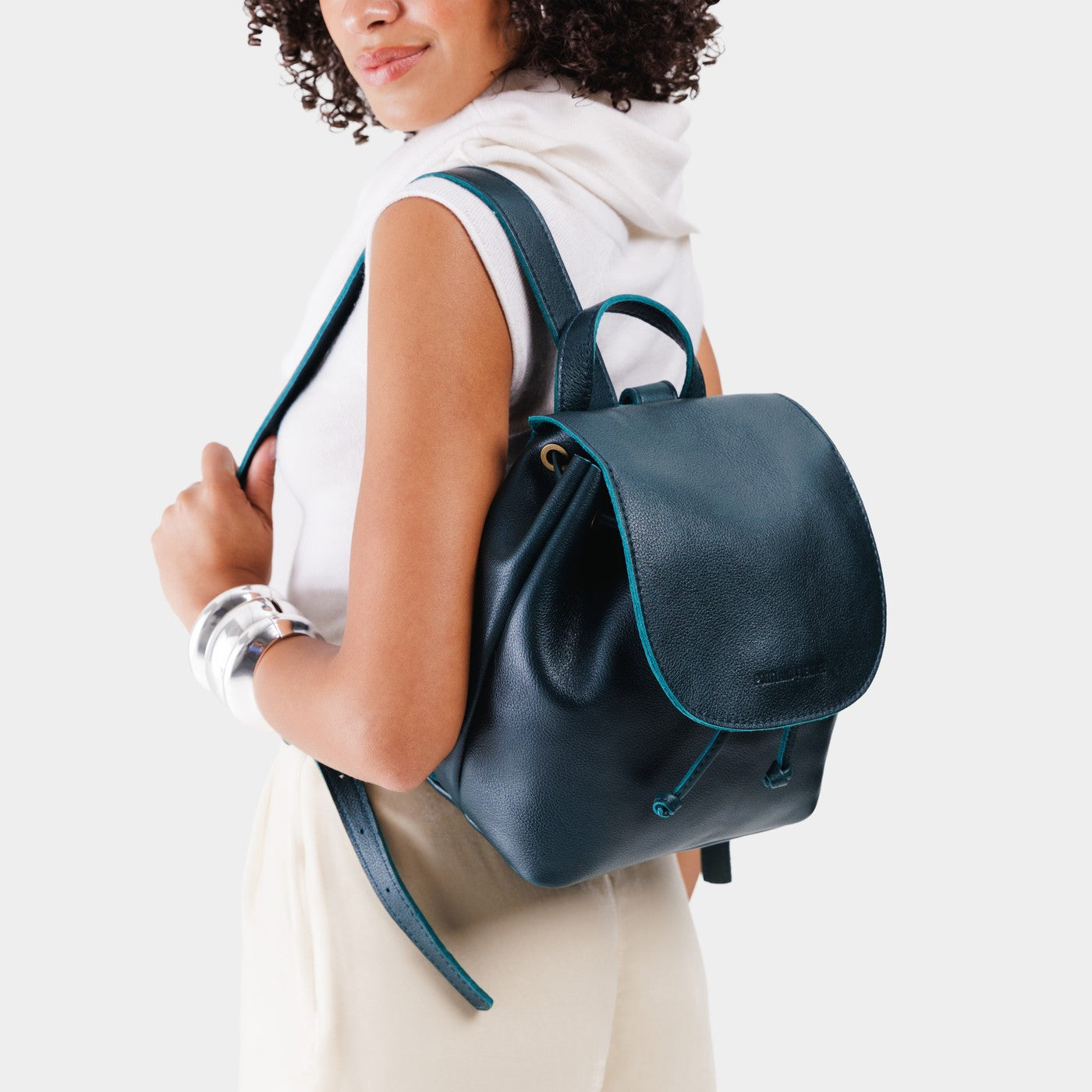 Boreal | Dark blue leather drawstring backpack being worn by a person wearing a white shirt.