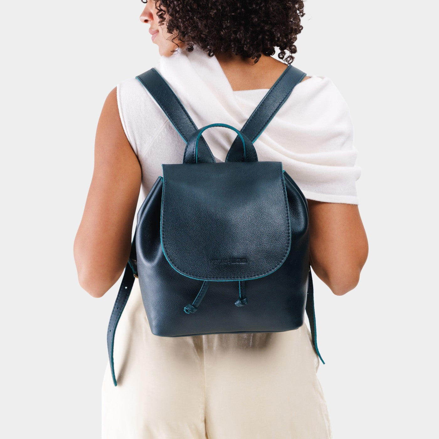Boreal | Dark blue leather drawstring backpack being worn by a person wearing a white shirt.
