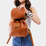 Sienna | Pebbled leather drawstring backpack being held by a person.