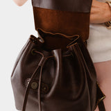 Coldbrew | Pebbled leather drawstring backpack being held by a person.