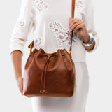Nutmeg Large | Model holding slouchy crossbody bag with drawstring closure