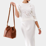 Nutmeg Large | Model holding slouchy crossbody bag with drawstring closure