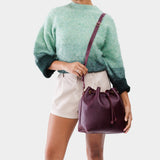 Plum Large | Model holding slouchy crossbody bag with drawstring closure