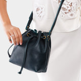 Boreal Small | Model holding slouchy crossbody bag with drawstring closure