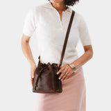 Coldbrew Small | Model holding slouchy crossbody bag with drawstring closure