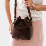 Coldbrew Small | Model holding slouchy crossbody bag with drawstring closure