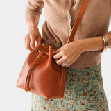 Sienna Small | Model holding slouchy crossbody bag with drawstring closure