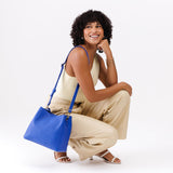 Astro Blue | Model wearing symmetrical bucket bag with latch closure and removable crossbody strap