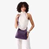 Empire | Model wearing symmetrical bucket bag with latch closure and removable crossbody strap