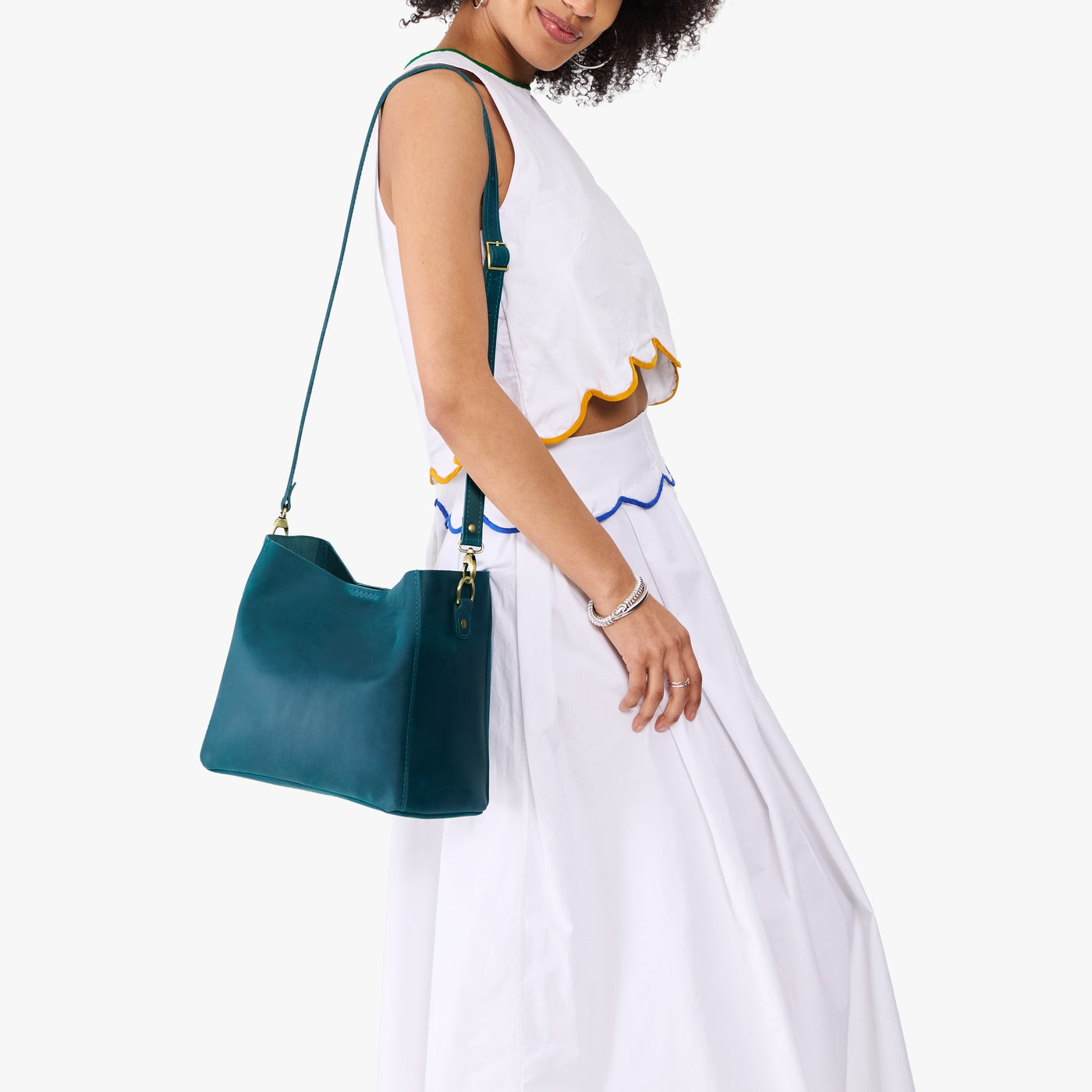 Westward Blue | Model wearing symmetrical bucket bag with latch closure and removable crossbody strap
