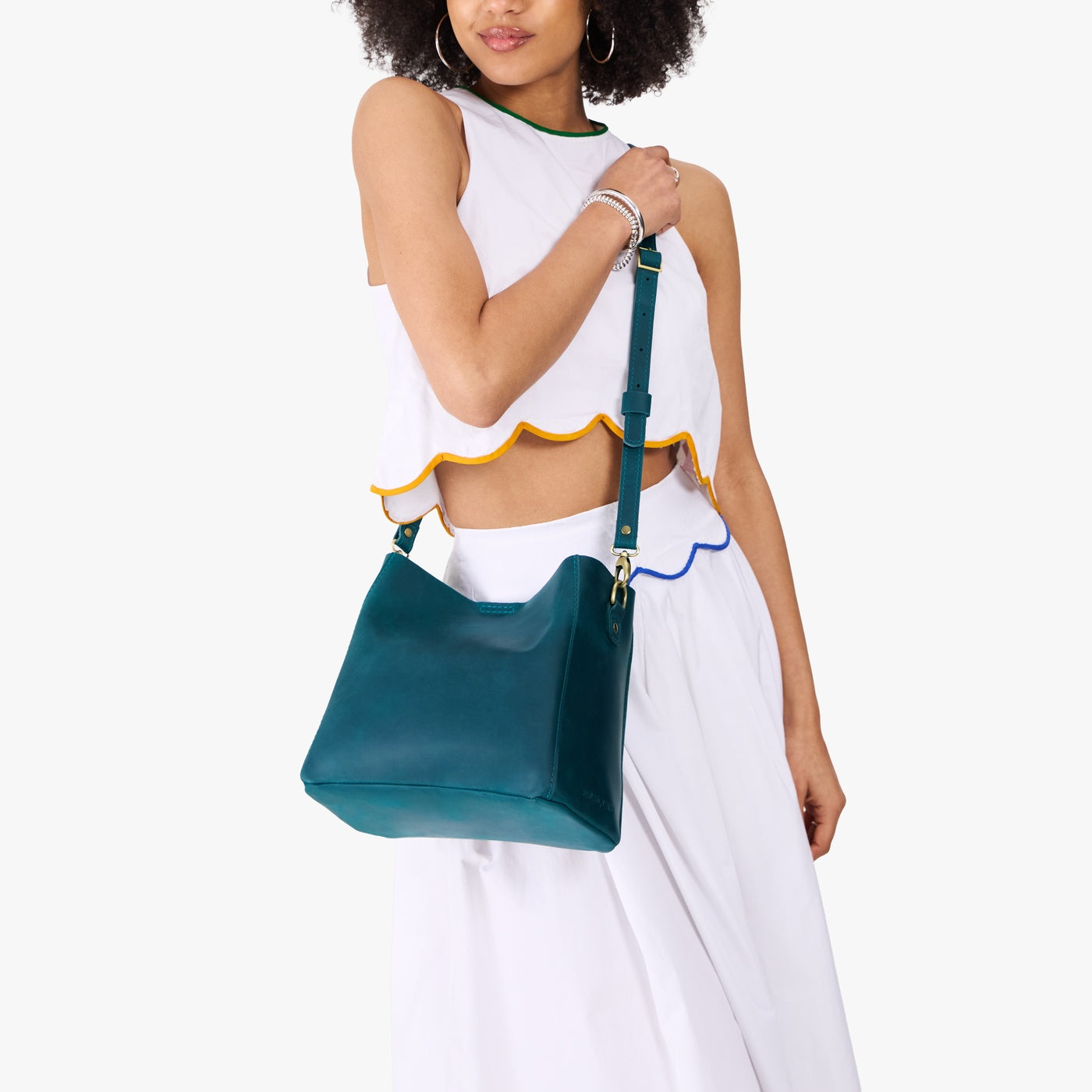 Westward Blue | Model wearing symmetrical bucket bag with latch closure and removable crossbody strap