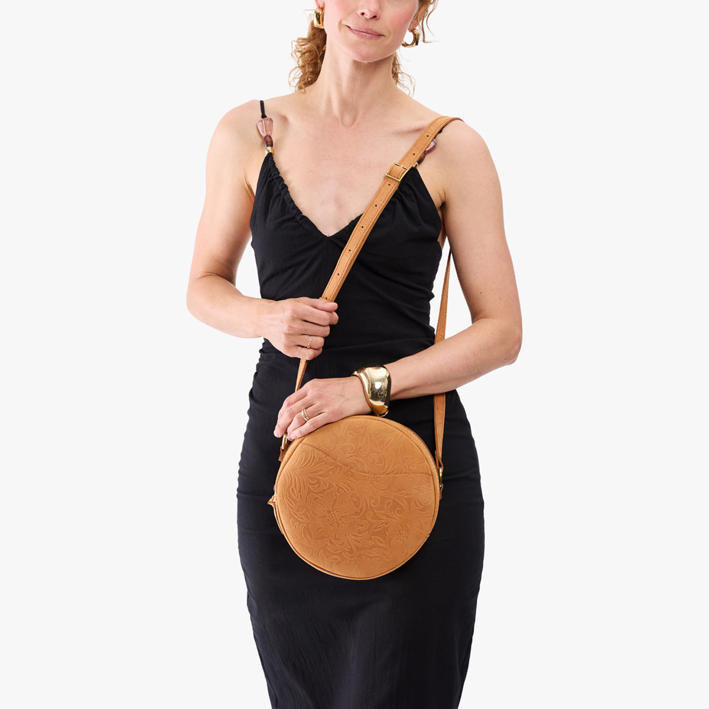 Desert Flower | Model wearing a large circle shaped crossbody bag with top zipper