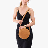Desert Flower | Model wearing a large circle shaped crossbody bag with top zipper