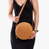 Desert Flower | Model wearing a large circle shaped crossbody bag with top zipper