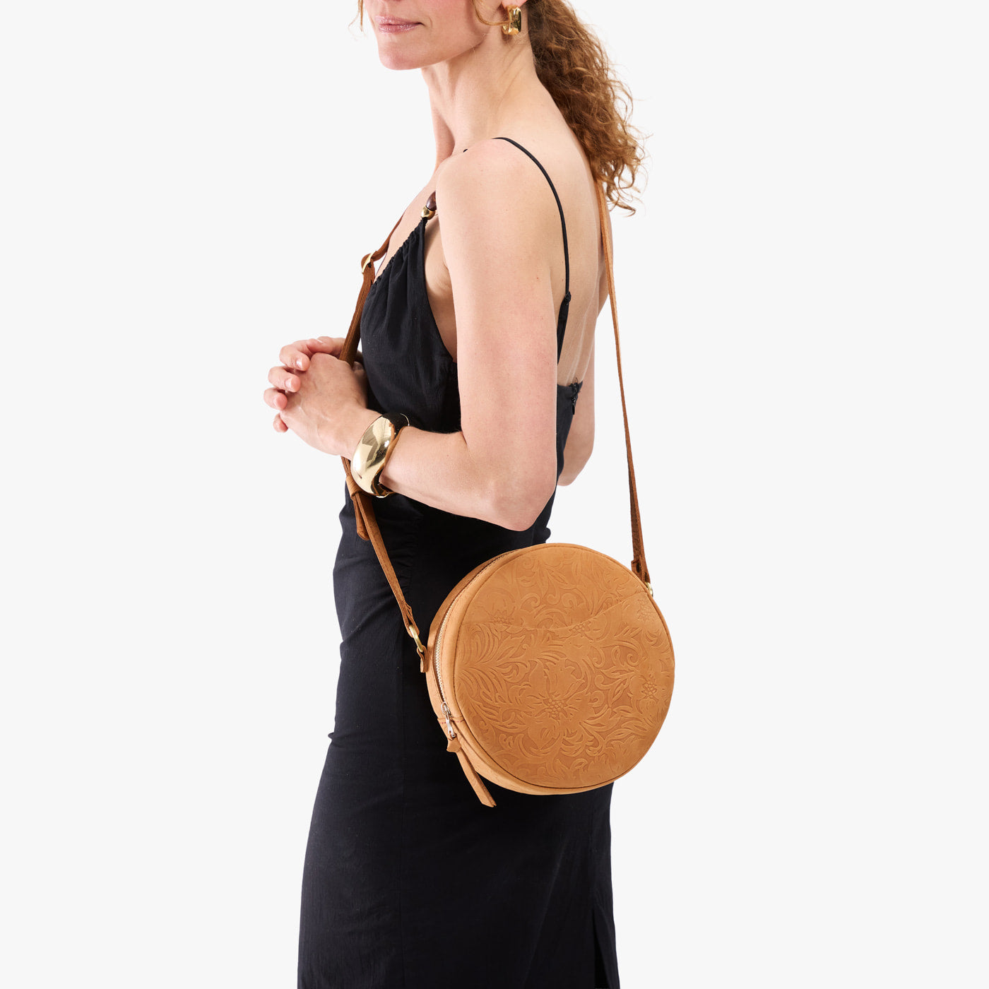 Desert Flower | Model wearing a large circle shaped crossbody bag with top zipper