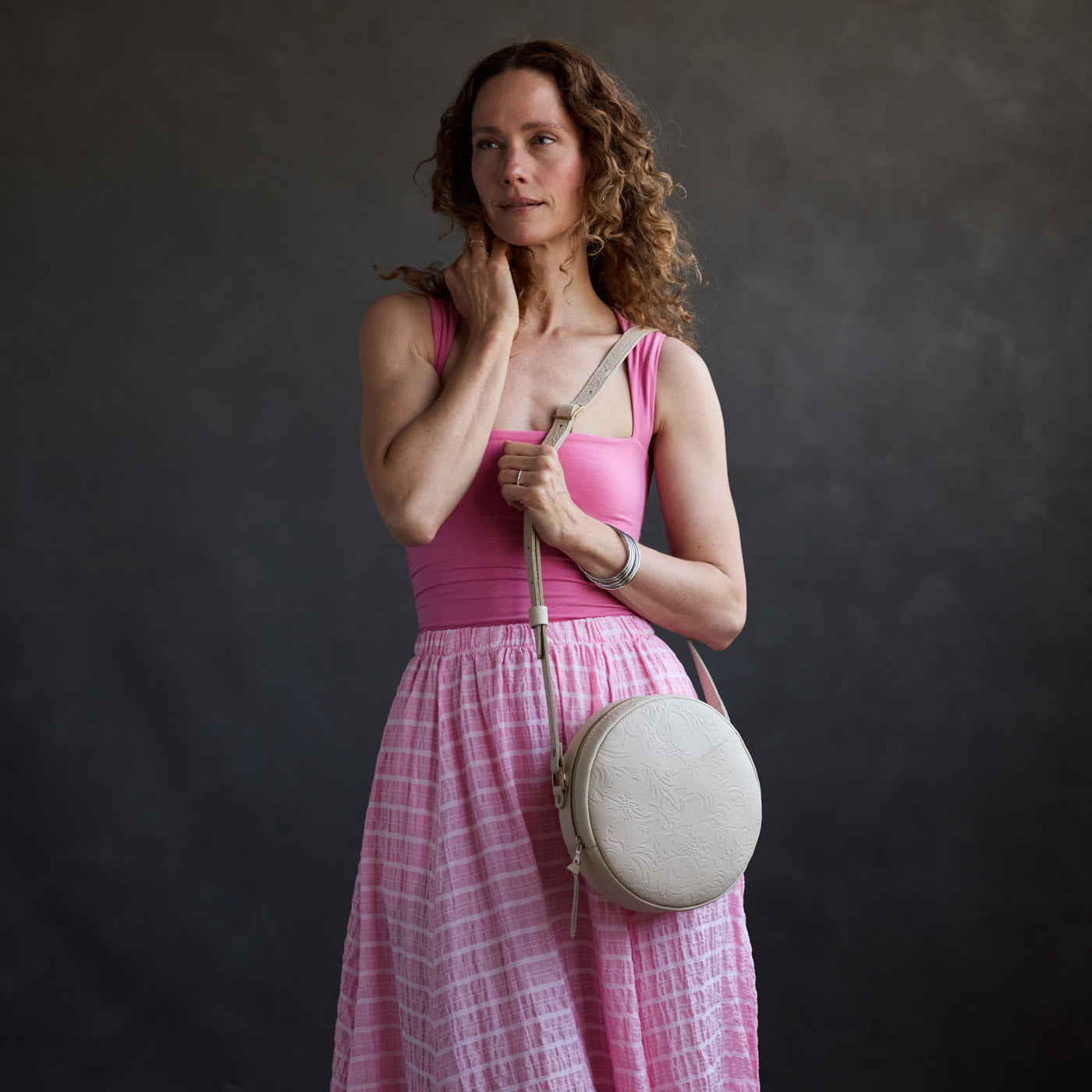Jasmine | Model wearing a large circle shaped crossbody bag with top zipper