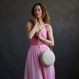 Jasmine | Model wearing a large circle shaped crossbody bag with top zipper