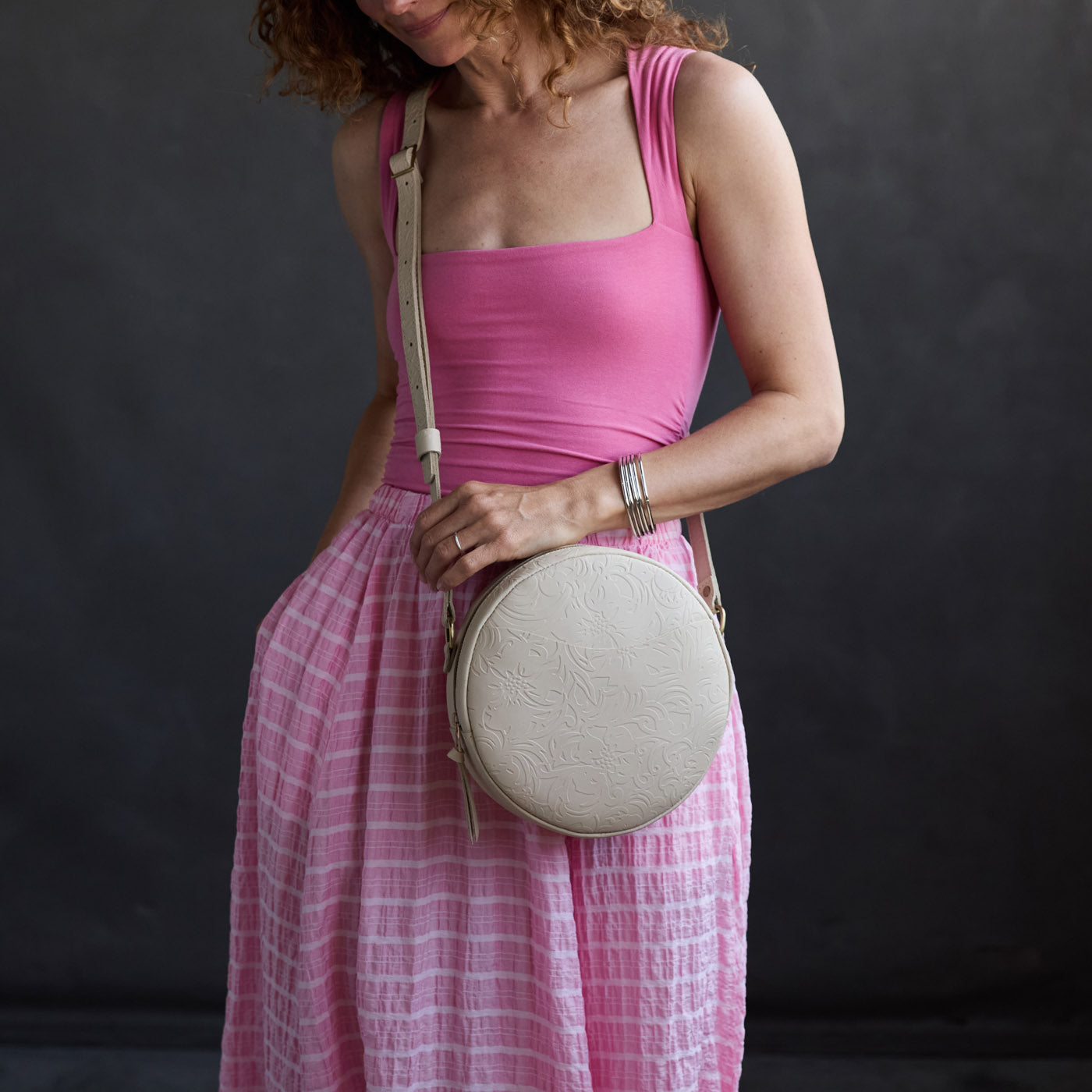 Jasmine | Model wearing a large circle shaped crossbody bag with top zipper