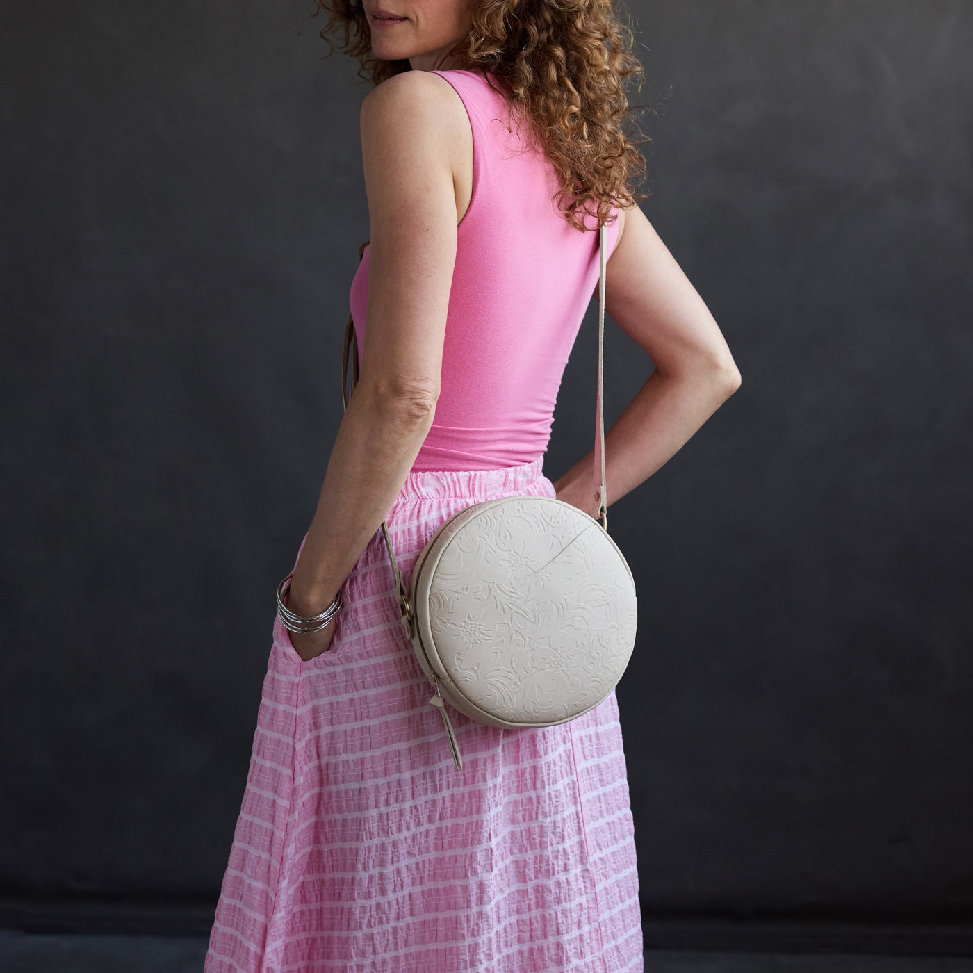 Jasmine | Model wearing a large circle shaped crossbody bag with top zipper
