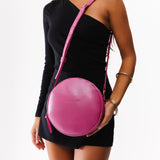 Lip Gloss Large | Model holding circle shaped crossbody bag with top zipper