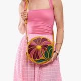 Wildflower Sunshine Large | Model holding circle shaped crossbody bag with top zipper