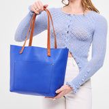 Astro Blue Classic | Model wearing large leather tote bag with sturdy bridle handles and front pocket