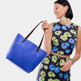 Astro Blue Classic | Model wearing large leather tote bag with sturdy bridle handles and front pocket