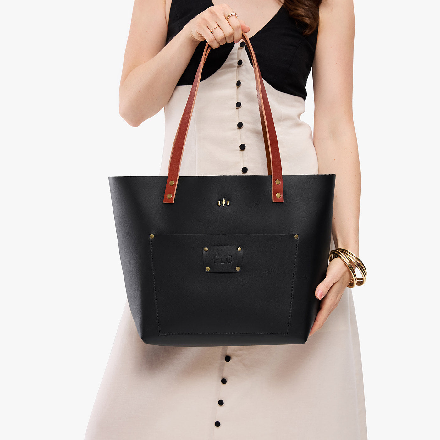 Black*Classic | Leather Tote Bag with bridle leather handles and monogram plate being held by a model