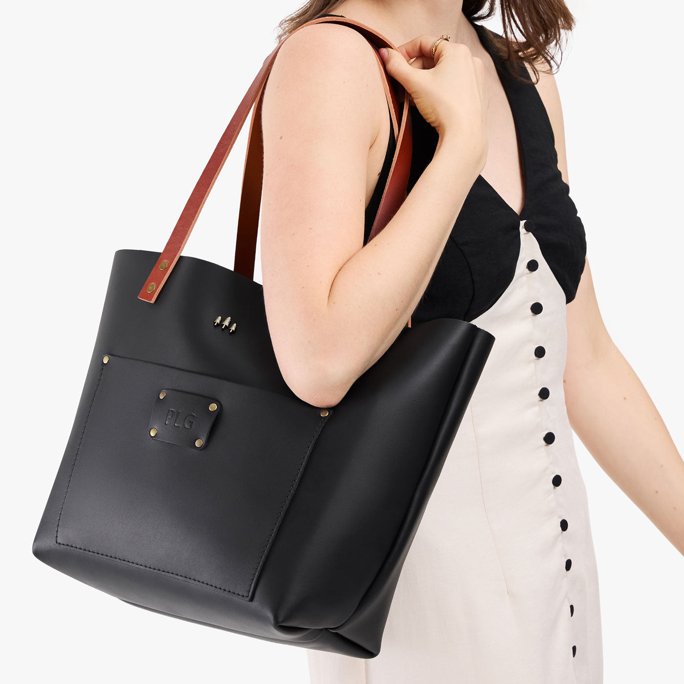 Black*Classic | Leather Tote Bag with bridle leather handles and monogram plate being held by a model