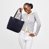 Velvet Blue Classic | Model holding large leather tote bag with sturdy bridle handles and front pocket