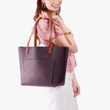 Larkspur Classic | Model holding large leather tote bag with sturdy bridle handles and front pocket