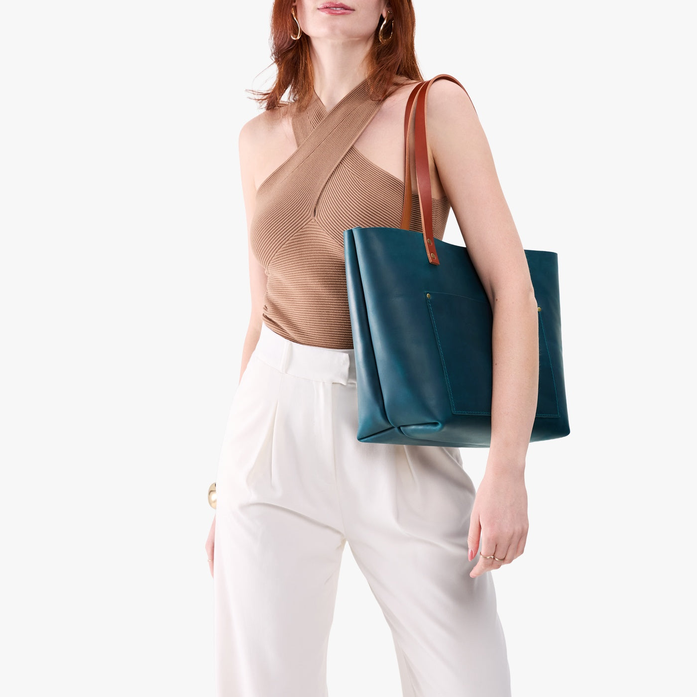 Westward Blue*Classic | Model holding large leather tote bag with sturdy bridle handles and front pocket