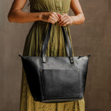 Pebbled--black Zipper | Model holding large zipper leather tote bag with sturdy bridle handles and front pocket